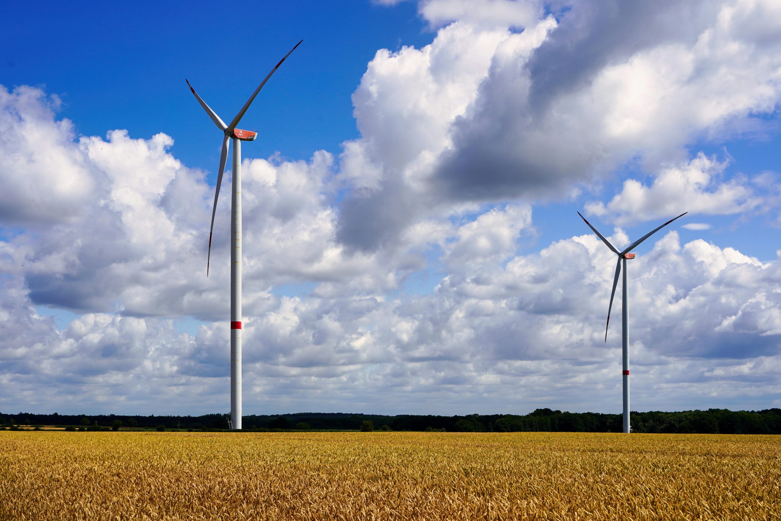 Turbiny wiatrowe na tle błękitnego nieba - symbol inwestycji OZE